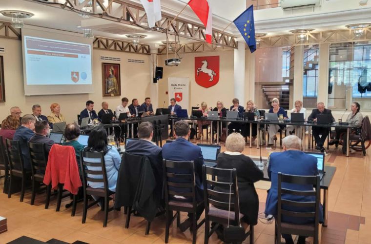 Sesja Rady Miasta Konina. Na zdjęciu widać radnych oraz prezydentów przy stole w sali obrad w ratuszu.