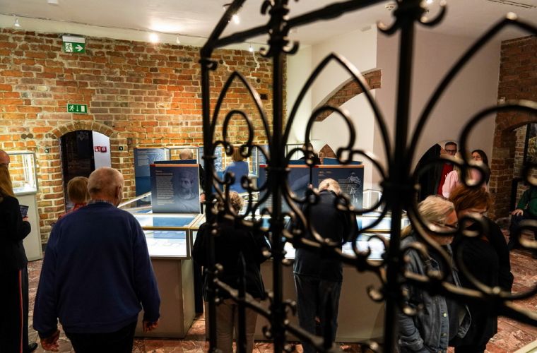 Król na zamku. Na zdjęci widać na pierwszym planie kratę wejściową, za nią sale zamkową i ludzi.