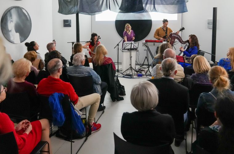 Na zdjęciu widać publiczność w tle oraz zespół grający koncert w Wieży Ciśnień