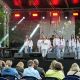 Zdjęcie przedstawia grupę artystów na scenie podczas koncertu na migi "Zobacz jak słyszę"