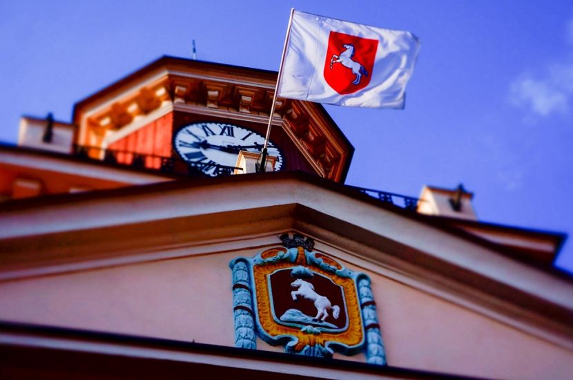 Ważny komunikat ws. bezpieczeństwa w konińskich szkołach. Na zdjęciu widać wieżę ratusza z powiewającą na niej flagą.
