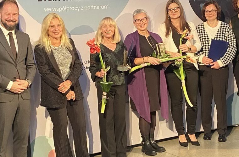 Koniński MOPR laureatem konkursu „Wielkopolska Otwarta na Usługi Społeczne – edycja 2025”. Na zdjęciu - na scenie stoją laureaci i organizatorzy konkursu ze statuetkami.