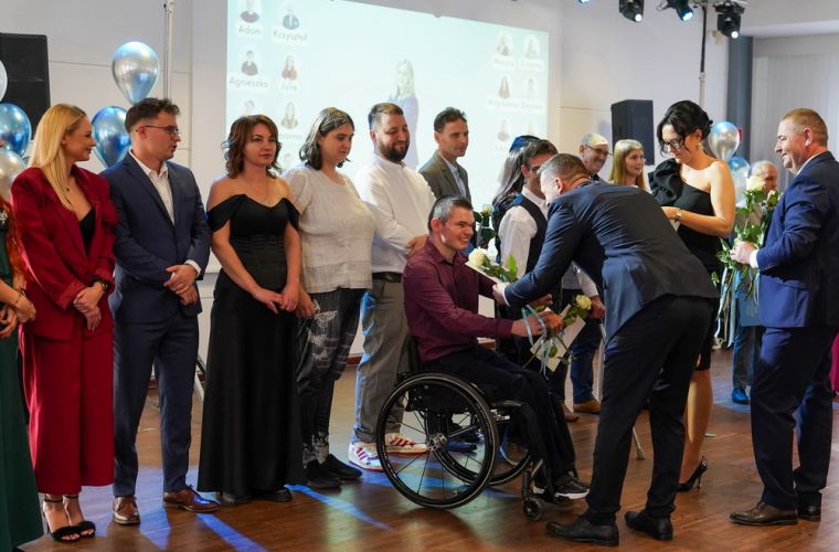 15 lat Zakładu Aktywności Zawodowej w Posadzie. Na zdjęciu widać oosby stojące na scenie, którym wręczane są podziękowania za współpracę.