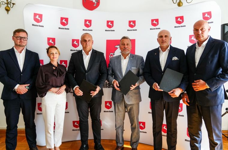 List intencyjny w sprawie zasilania data center podpisany. Na zdjęciu widać 6 osób stojących na tle ścianki reklamowej Miasta Konina, która jest biała i opatrzona herbami miasta.