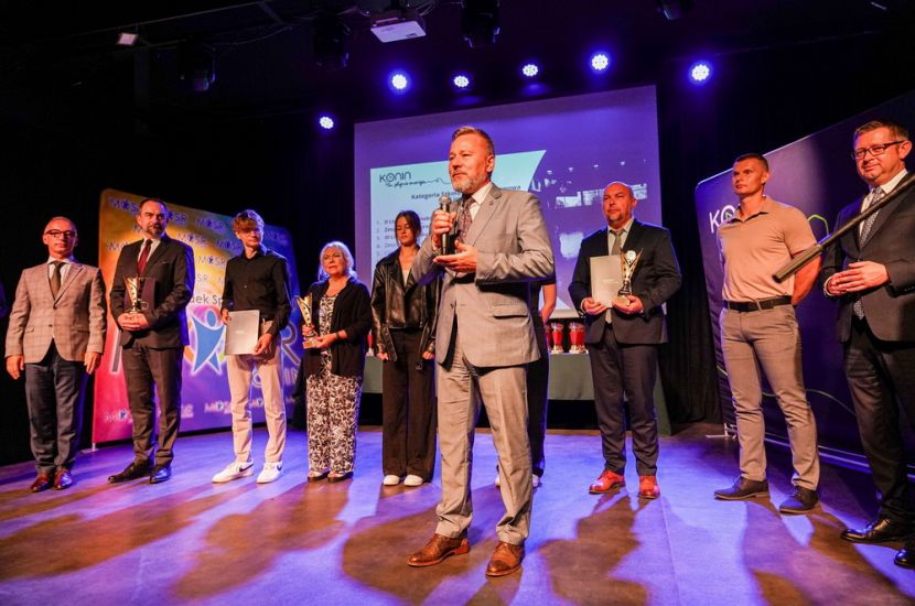 Sportowe podsumowanie roku szkolnego 2024/2025. Na zdjęciu prezydent Piotr Korytkowski przemawia ze sceny do uczestników, za nim stoją nagrodzeni sportowcy.