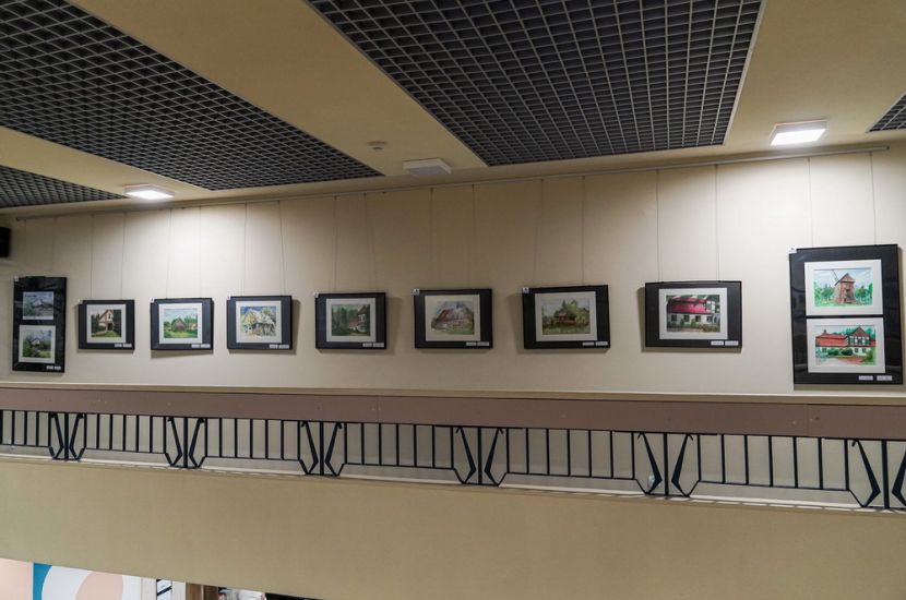 Powarsztatowe akwarele w bibliotece. Na zdjęciu widać hol biblioteki z wyeksponowanymi na ścianie pracami.