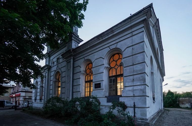 Przetarg na modernizację synagogi ogłoszony. Na zdjęciu widoczna jest synagoga os strony ulicy, z rozświetlonymi oknami.