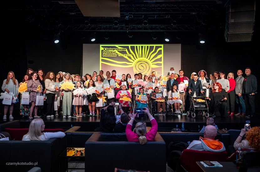 V Integracyjny Festiwal Piosenki „RAZEM” – muzyka, emocje i wyjątkowa integracja. Na zdjęciu artyści pozują na scenie do wspólnego zdjęcia.