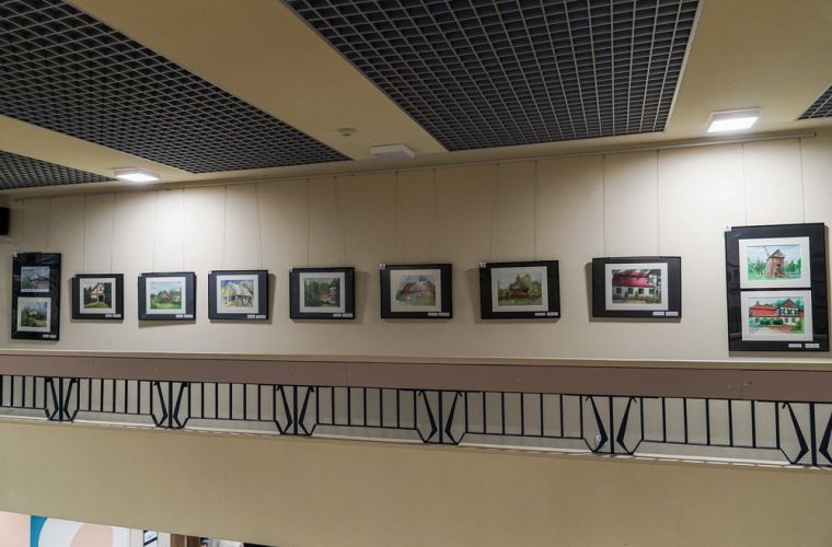 Powarsztatowe akwarele w bibliotece. Na zdjęciu widać hol biblioteki z wyeksponowanymi na ścianie pracami.