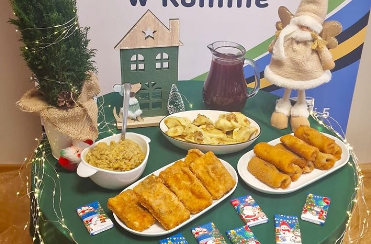 Wigilia dla mieszkańców. Na zdjęciu na tle banera MOPR widać stół zastawiony potrawami wigilijnymi.