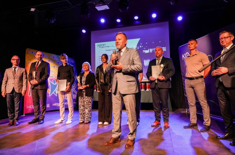 Sportowe podsumowanie roku szkolnego 2024/2025. Na zdjęciu prezydent Piotr Korytkowski przemawia ze sceny do uczestników, za nim stoją nagrodzeni sportowcy.