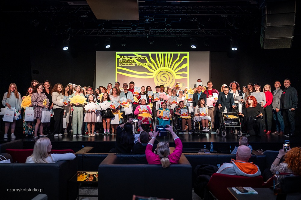 V Integracyjny Festiwal Piosenki „RAZEM” – muzyka, emocje i wyjątkowa integracja. Na zdjęciu artyści pozują na scenie do wspólnego zdjęcia.