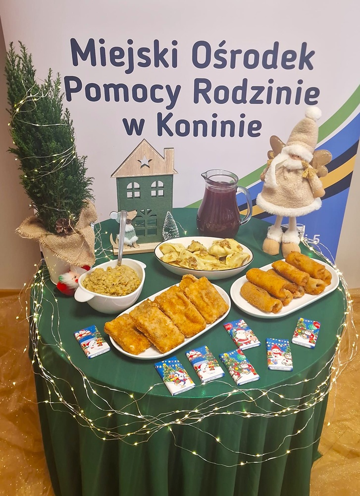 Wigilia dla mieszkańców. Na zdjęciu na tle banera MOPR widać stół zastawiony potrawami wigilijnymi.