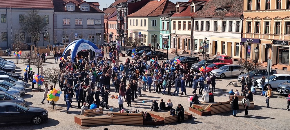 Konin na niebiesko – wspólne obchody Światowego Dnia Świadomości Autyzmu. Na zdjęciu zrobionym z góry widać tłum ludzi w niebieskich barwach, tańczących na rynku.