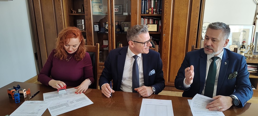 Konin usunie odpady z nielegalnego składowiska śmieci. Na zdjęciu widać, jak siedzący za stołem skarbnik Konina, prezes WFOŚiGW oraz prezydent Konina podpisują umowę pożyczki.