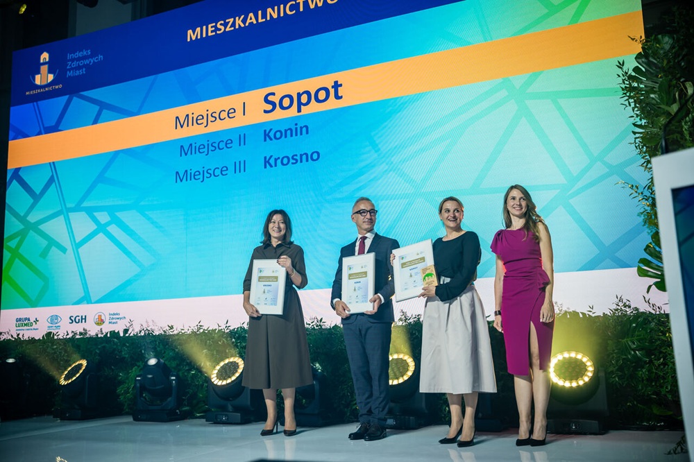Indeks Zdrowych Miast 2025. Konin drugi w kategorii Mieszkalnictwo. Na zdjęciu trzy osoby, w środku zastępca prezydenta Witold Nowak, odbierają nagrody.