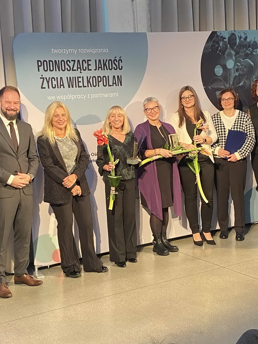 Koniński MOPR laureatem konkursu „Wielkopolska Otwarta na Usługi Społeczne – edycja 2025”. Na zdjęciu - na scenie stoją laureaci i organizatorzy konkursu ze statuetkami.