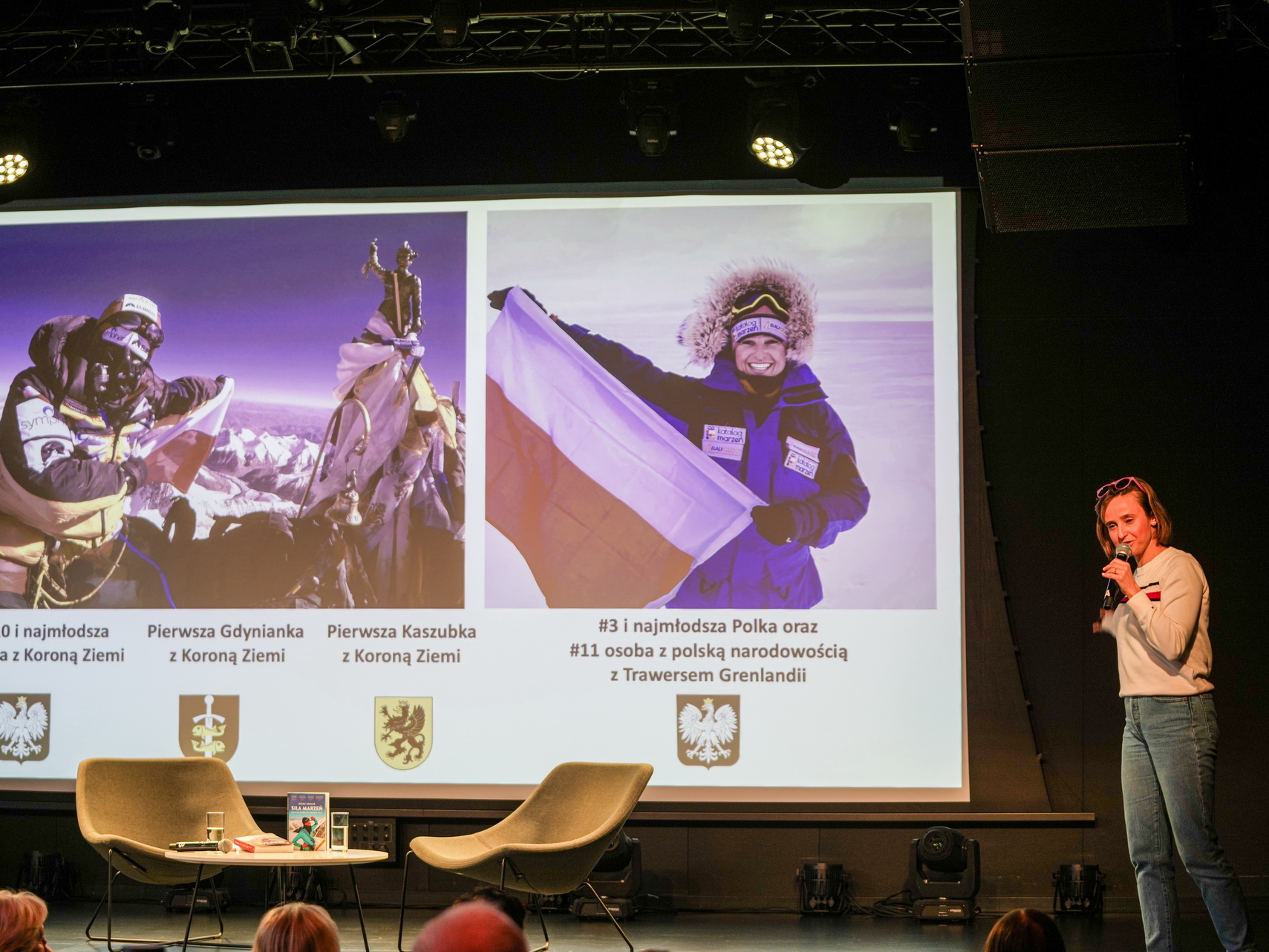 Zdjęcie przestawia Miłkę Raulin podczas spotkania autorskiego na zdjęciu widać również prezentację multimedialną przygotowaną przez autorkę