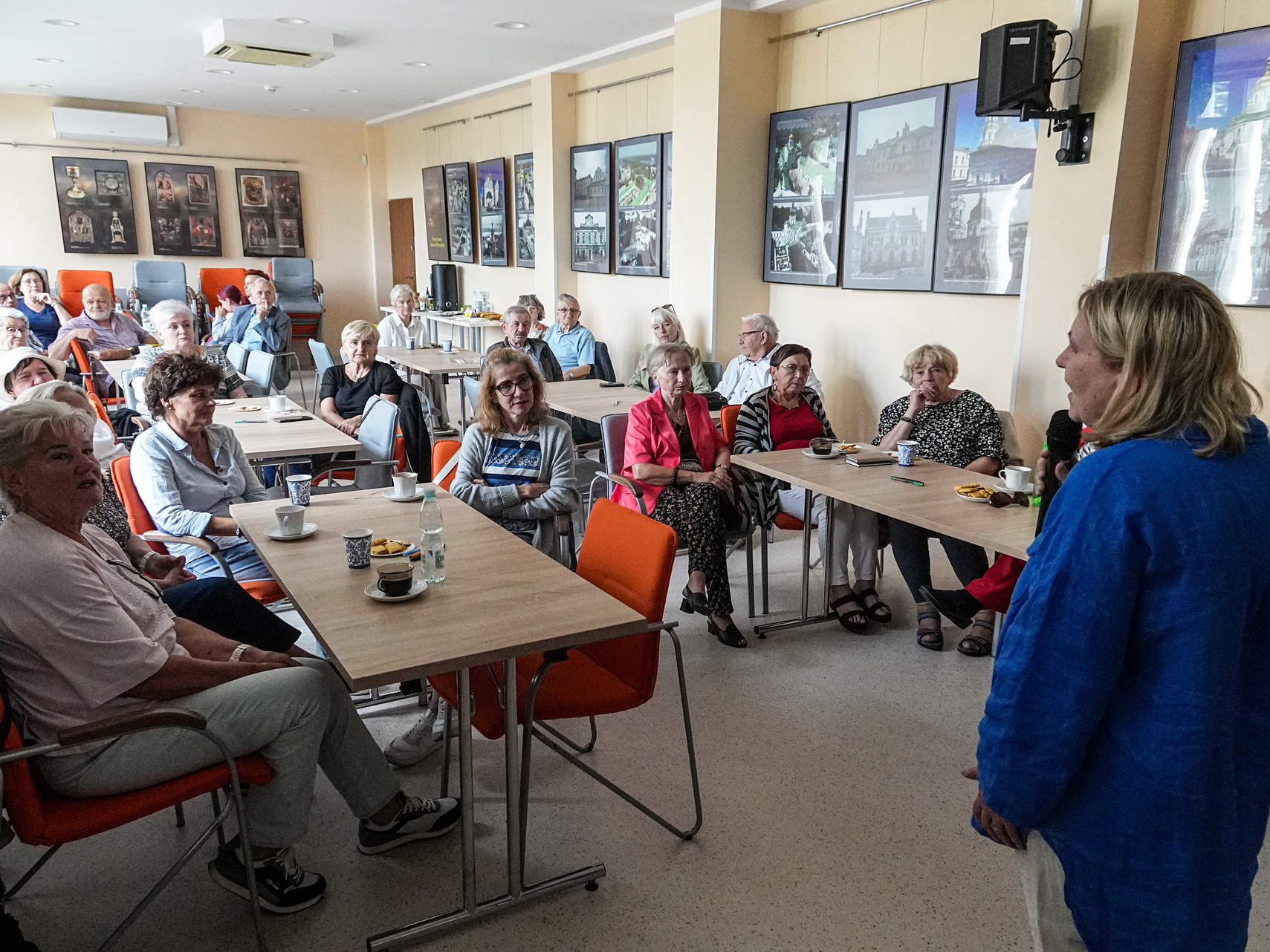 Na zdjęciu widzimy grupę osób w Bibliotece Publicznej podczas imprezy Kadr Fórmanka – archiwum fotograficzne